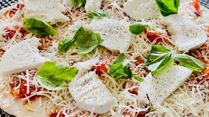 Margherita thin crust pizza with fresh basil and tomato